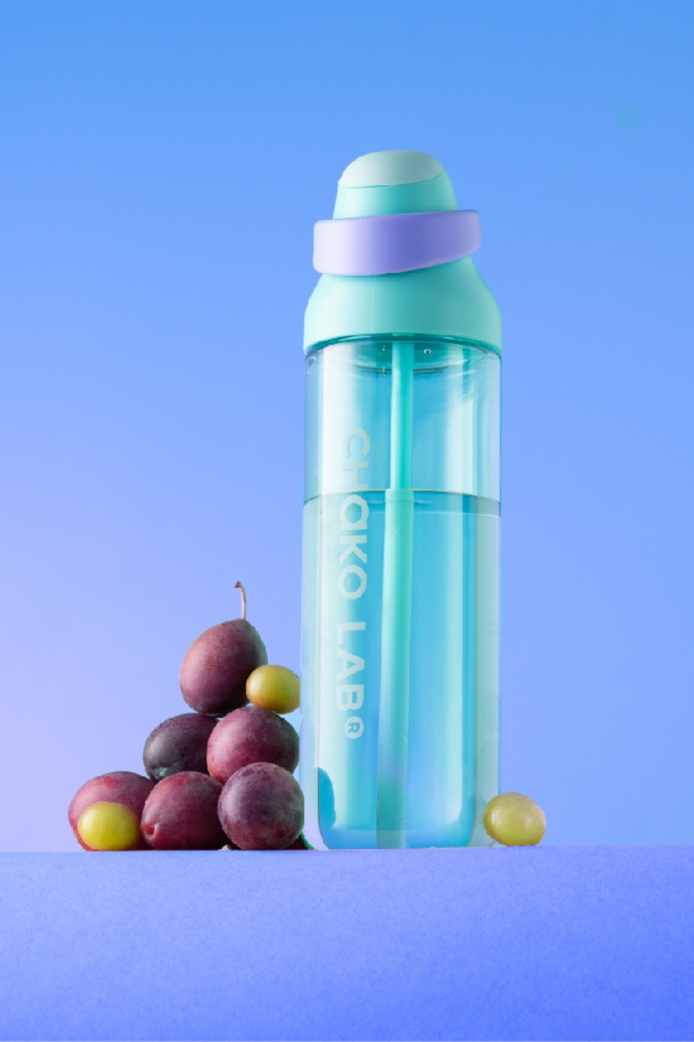 Kada Cup 888ml bottle in Pistachio beside grapes